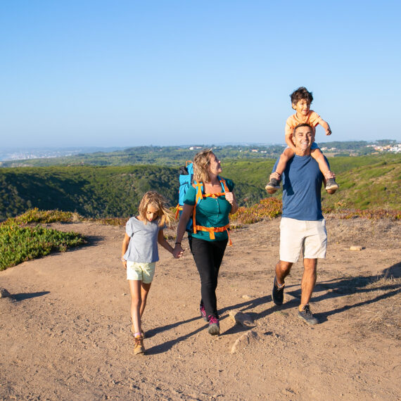 happy family couple children hiking countryside walking path excited boy riding dads neck full length nature recreation concept - Magainepanda.com